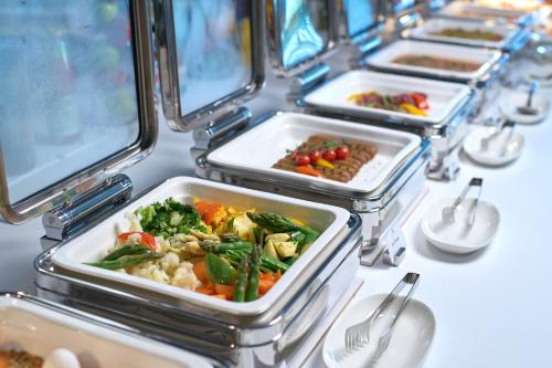 a row of trays of food on a table at Hotel Holiday International in Sharjah