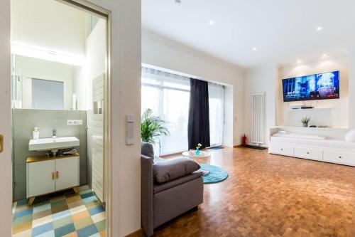 a living room with a couch and a sink at DR Apartments Friedrichshain in Berlin