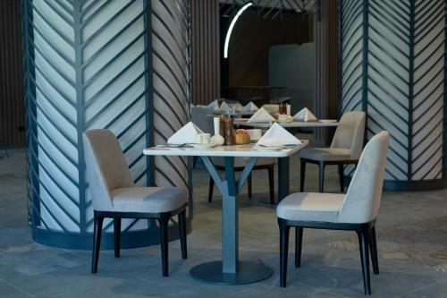 a table and chairs in a restaurant with a table at Hotel Holiday International in Sharjah