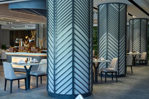 a restaurant with tables and chairs and a bar at Hotel Holiday International in Sharjah