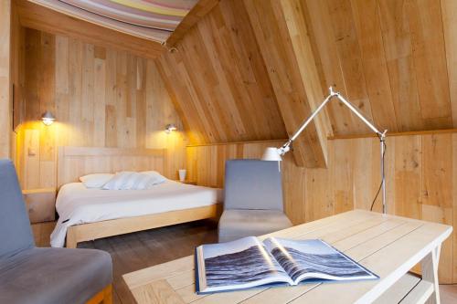 a bedroom with a bed and a table with a book at Emeria Dinard Thalasso Spa in Dinard