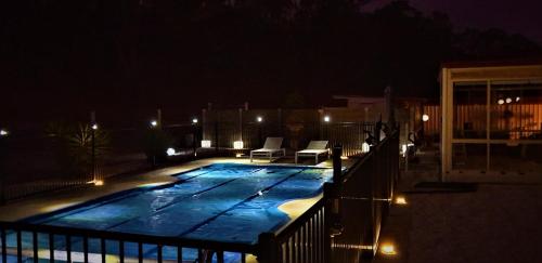 a night time view of a swimming pool with lights at Alma Retreat, King bed, Family, Pet Friendly in Alma