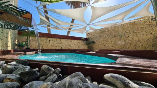 ein Schwimmbad mit Springbrunnen in einem Gebäude in der Unterkunft פאטה מורגנה אואזיס - בית נופש פרטי עם בריכה מחוממת in Be’er Scheva