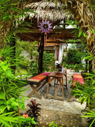 a patio with a table and a bench and an umbrella at Sumatra Orangutan Discovery Villa in Bukit Lawang