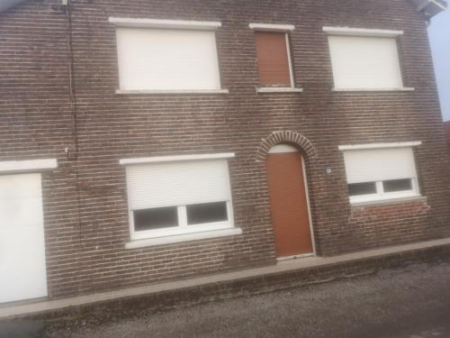 ceglany budynek z białymi oknami i drzwiami w obiekcie Gîte chez Danielle w mieście Blessy