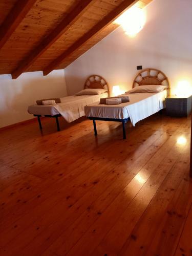 two beds in a room with a wooden floor at Sal&Love apt in Porto Antigo in Santa Maria