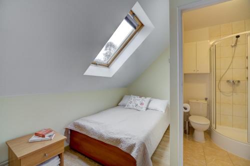 Habitación pequeña con cama y baño. en Willa Karla, en Krynica-Zdrój