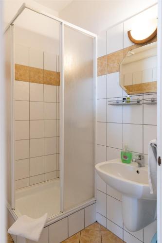 a bathroom with a shower and a sink at Betli Panzió in Zalaegerszeg