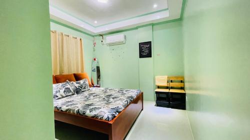 a small bedroom with a bed in a room with green walls at Sephreen Home stay in San Juan
