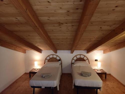 two beds in a room with wooden ceilings at Sal&Love apt in Porto Antigo in Santa Maria
