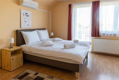 a bedroom with a bed with two pillows on it at Betli Panzió in Zalaegerszeg
