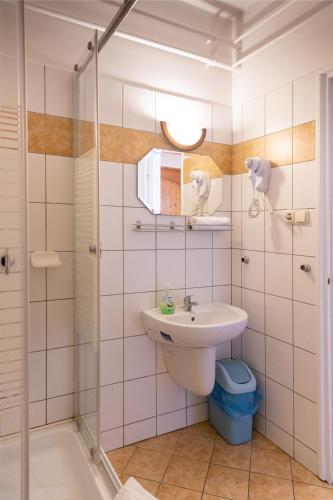 a bathroom with a sink and a shower at Betli Panzió in Zalaegerszeg