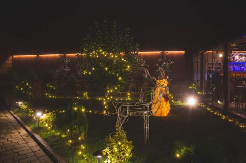 a garden at night with a bench and lights at Boutique Hotel Kviria in Tʼelavi