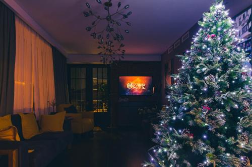 a christmas tree in a living room with a tv at Boutique Hotel Kviria in Tʼelavi