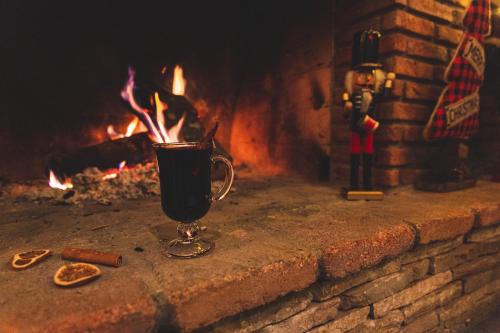 a cup of coffee in front of a fireplace at Boutique Hotel Kviria in Tʼelavi