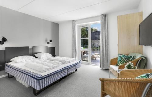 1 dormitorio con 1 cama, 1 silla y 1 ventana en Awesome Apartment In Allinge With Sauna en Allinge