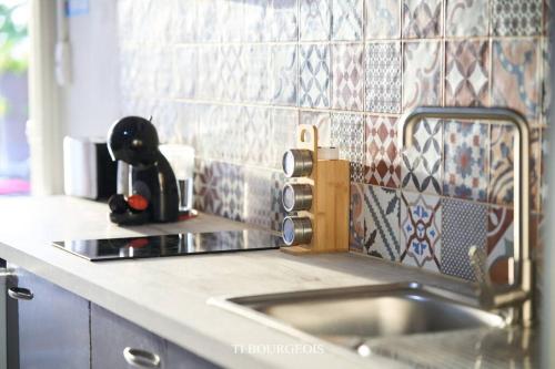 a kitchen counter with a sink and a mixer at Le Ti Bourgeois in Rivière-Salée