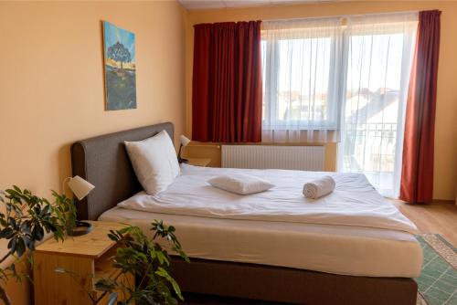 a bedroom with a bed with two pillows on it at Betli Panzió in Zalaegerszeg
