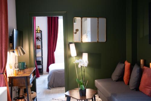 ein Wohnzimmer mit grünen Wänden und einem Sofa in der Unterkunft Les Gites By Carpe Diem in Les Andelys