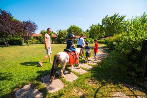 a group of people riding a horse on a path at Park Residence Il Gabbiano in Moniga