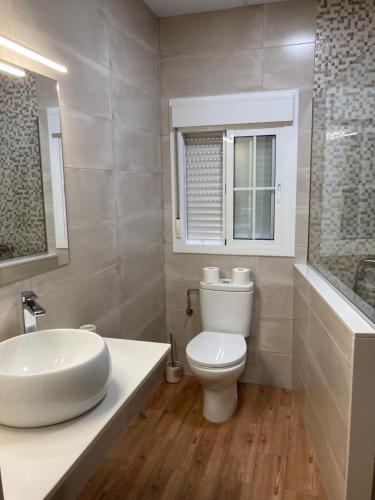 een badkamer met een witte wastafel en een toilet bij Boutique house LujoPobre in Montilla
