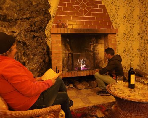 a couple of people sitting in front of a fireplace at Santana in Nature Bed & Breakfast in Santana