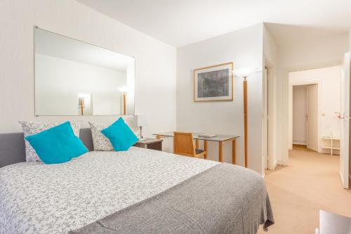 ein Schlafzimmer mit einem großen Bett mit blauen Kissen in der Unterkunft Luxury Living in Saint Germain in Paris
