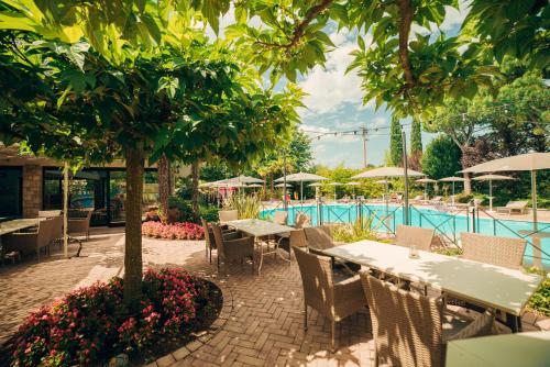 a patio with tables and chairs next to a pool at Park Residence Il Gabbiano in Moniga
