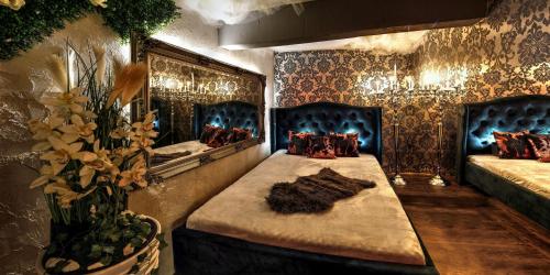 Cette chambre comprend deux lits et un grand miroir. dans l'établissement Afrodita Wellness Apartman Prague, à Prague