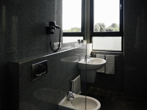 a bathroom with a sink and a toilet and a window at Loto Business Hotel in Rome