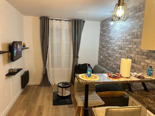 Televízia a/alebo spoločenská miestnosť v ubytovaní Studio moderne proche Disney Land