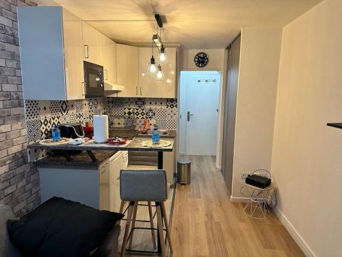 a kitchen with a counter and a table and chairs at Studio moderne proche Disney Land in Bussy-Saint-Georges