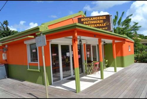 an orange and green building with a sign on it at Le Ti Bourgeois in Rivière-Salée