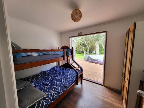 a bedroom with bunk beds and a door to a deck at 90 Mile Beach Escape in Seaspray