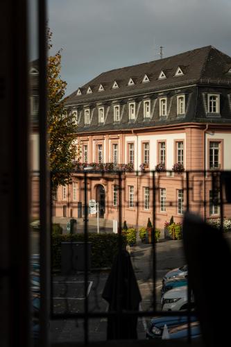 a large pink building with cars parked in front of it at Gasthause Zur Krone Hotel in Leimen