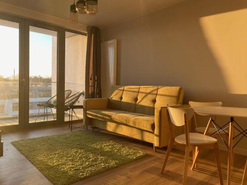 a living room with a couch and a table at UniQue 106 in Gdynia