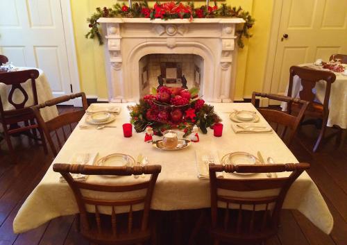 a table with a christmas centerpiece in front of a fireplace at Rachael's Dowry Bed and Breakfast in Baltimore