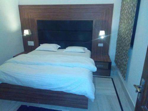 a bedroom with a large bed with a wooden headboard at Kailash Haveli in Bikaner