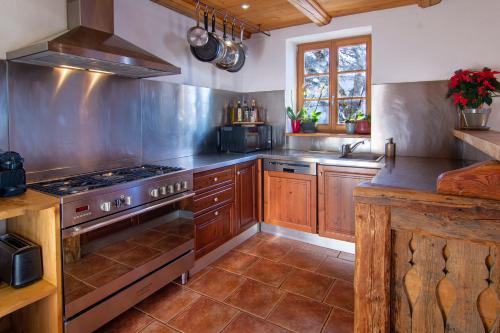 eine Küche mit Holzschränken und einem Herd mit Backofen in der Unterkunft Les Deux Tetes 2 Chez Fifine in Arc 1600