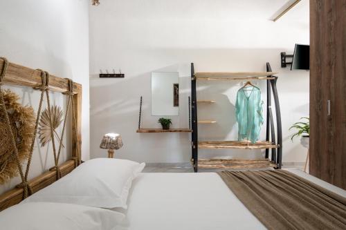 een slaapkamer met een bed en een jurk op een plank bij Simon Prince Prive in Vourvourou