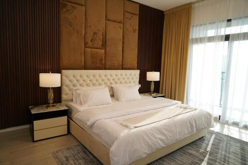 a bedroom with a large white bed with two lamps at Madinat Jumeirah Living in Dubai