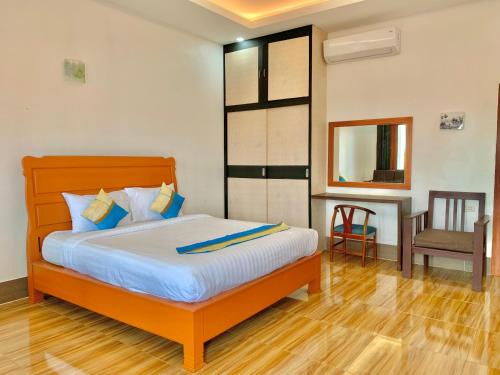 a bedroom with a bed and a chair in it at Nakasang Paradise Hotel in Nakasong