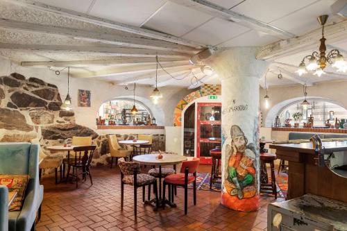 a restaurant with tables and chairs and a stone wall at Best Western Tidbloms Hotel in Gothenburg