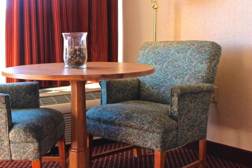 a table with two chairs and a vase on it at Regency Inn Richmond in Richmond