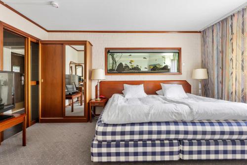 een hotelkamer met een bed en een televisie bij Best Western Hotel Scheele in Köping