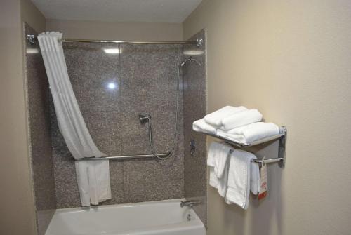 a bathroom with a shower and a toilet and towels at Super 8 by Wyndham Huntersville/Charlotte Area in Huntersville