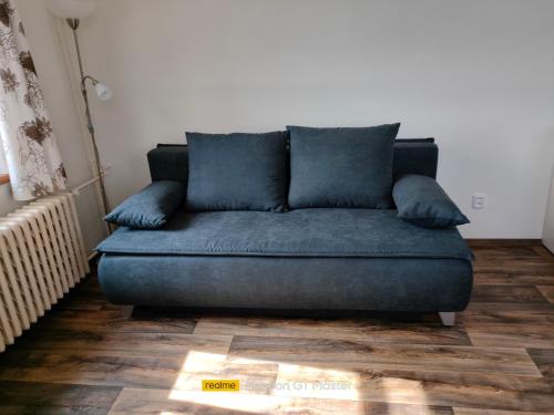 a blue couch sitting in a living room at Penzion Šumava - APARTMÁN in Horní Planá