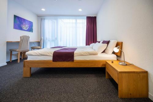a bedroom with a bed and a table and a window at Hotel Ochsen Rapperswil/BE in Rapperswil