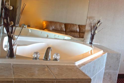 a bath tub in a bathroom with a couch at Regency Inn Richmond in Richmond