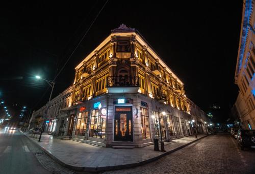 a lit up building on a city street at night at Grand Opera Hotel in Kutaisi